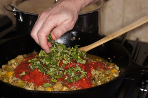 Add chopped tomatoes, tomato past, basil, vinegar and olives