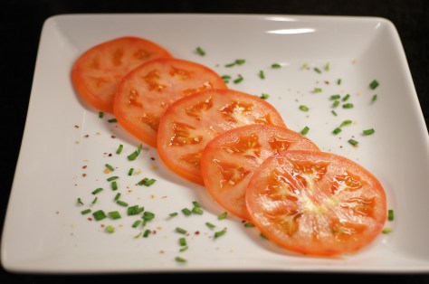 Place tomato slice on plate in a line